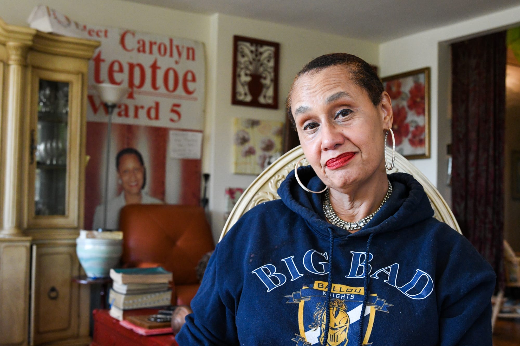 A woman in a blue sweatshirt in her living room.