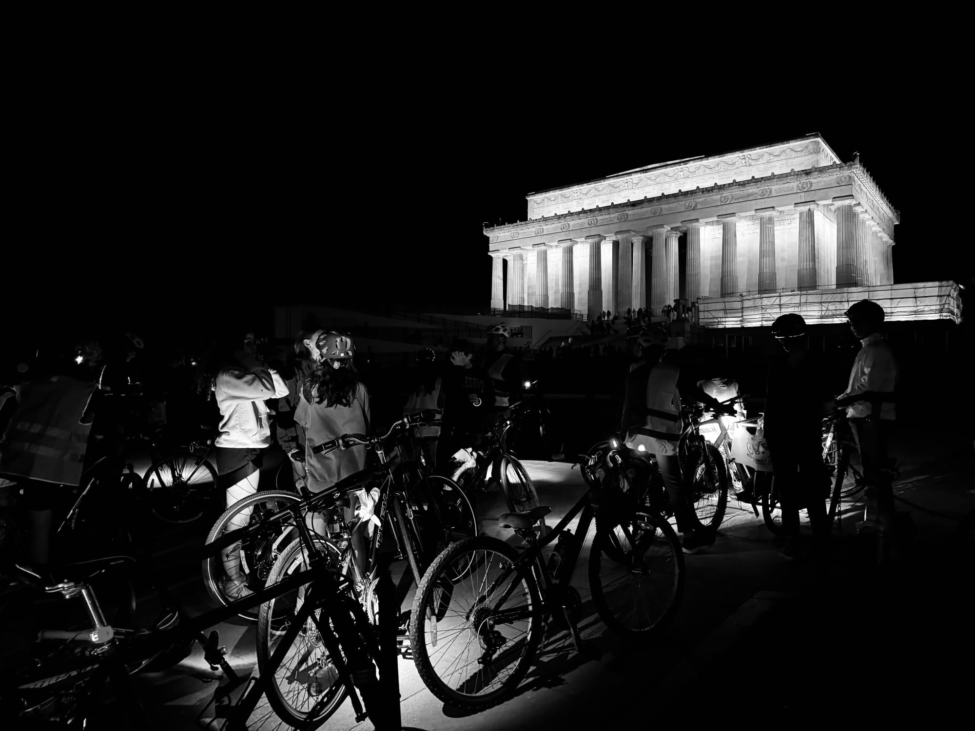 A black and white image of many young people and bikes outside the Lincoln Memorial in D.C.