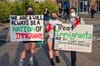 immigrant rights protestors holding signs at a columbia heights action