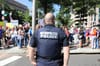 A uniformed D.C. police officer standing in front of a protest, with his back to the camera. 